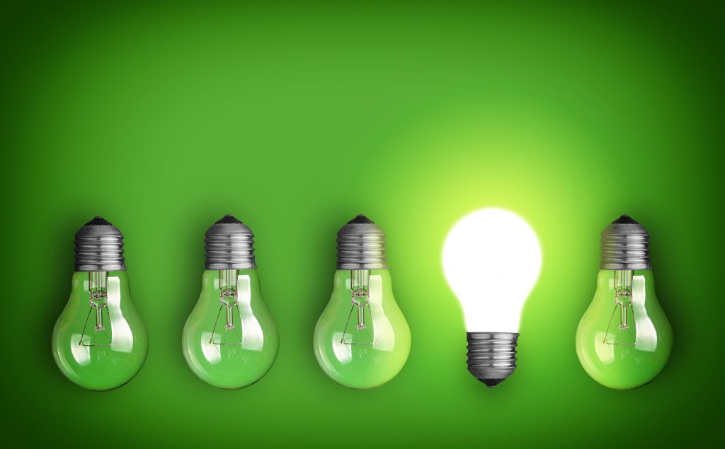 Five light bulbs and one glowing bulb